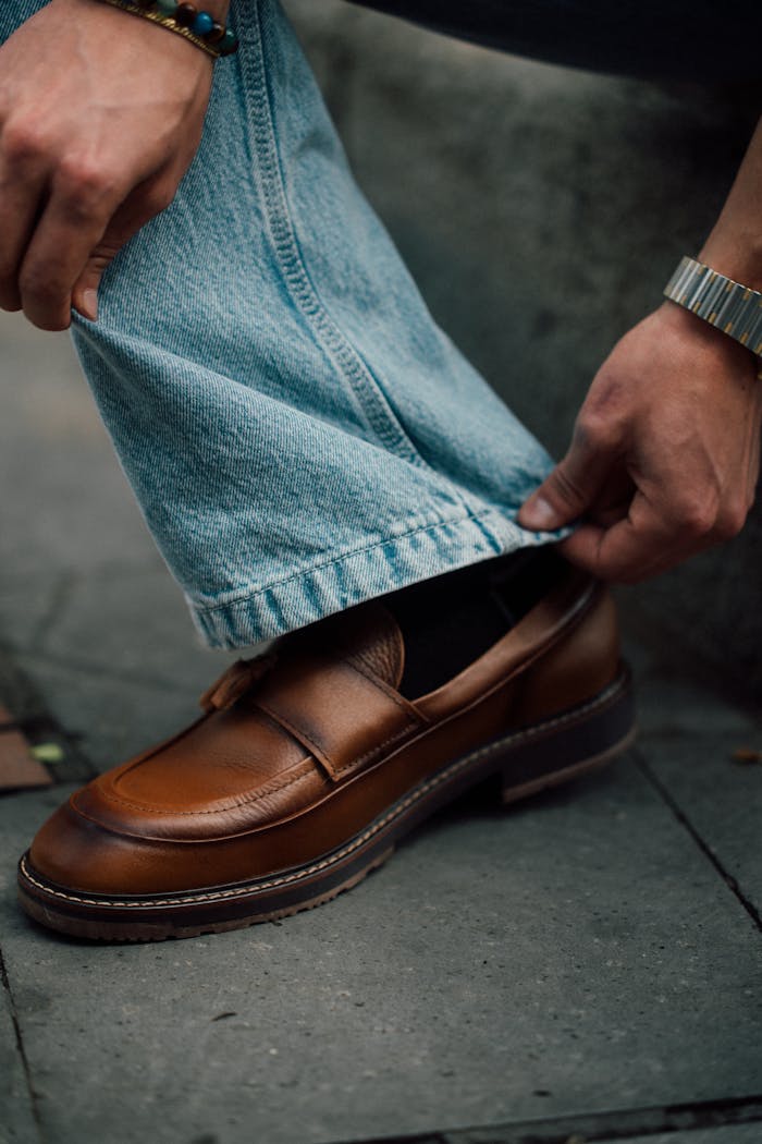 Home Stylish brown loafer paired with blue denim jeans in an urban setting of Cuenca, Ecuador.